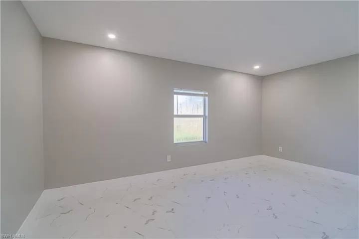 Unfurnished room featuring recessed lighting and marble look tiles