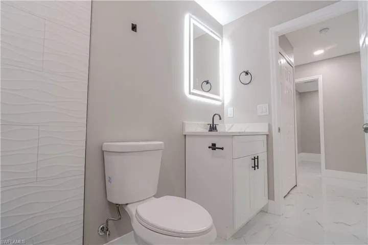 Bathroom with light marble finish floors and vanity
