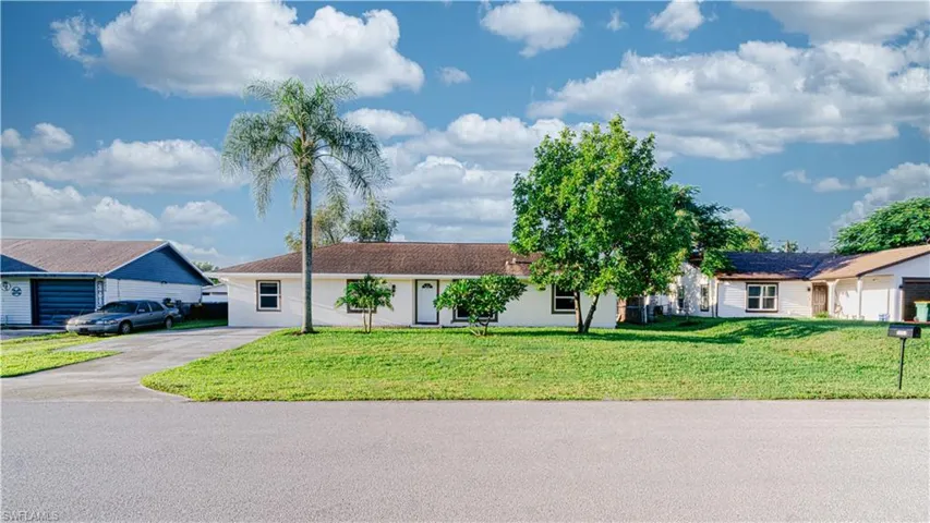 Single story home with concrete driveway, a front yard, and stucco siding