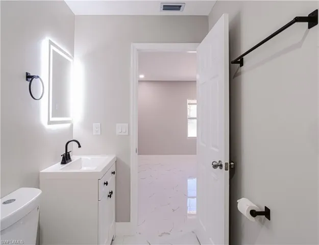 Bathroom with light marble finish floors and vanity