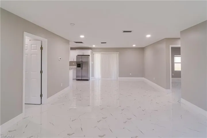 Unfurnished living room with recessed lighting and light marble finish flooring