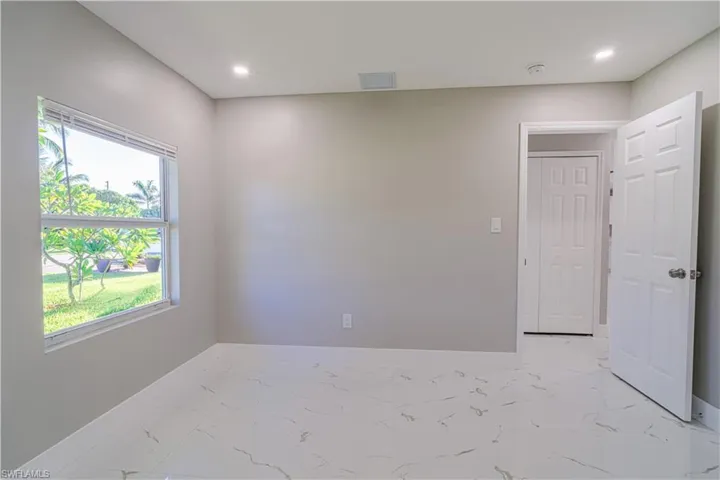 Empty room featuring light marble finish flooring and recessed lighting