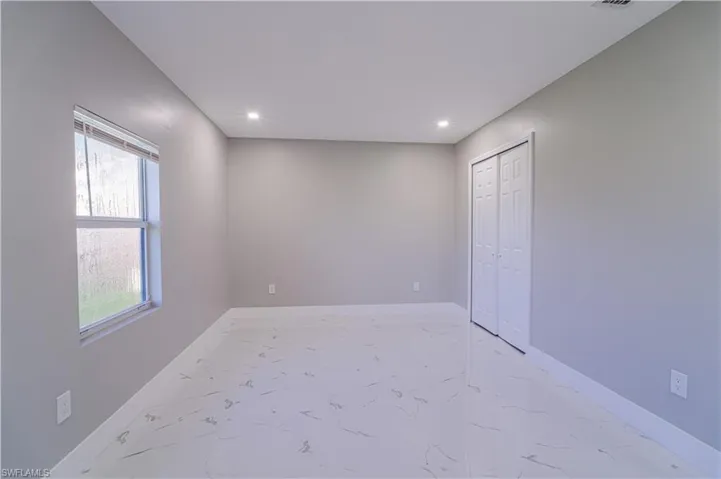 Unfurnished bedroom with recessed lighting, a closet, and light marble finish floors