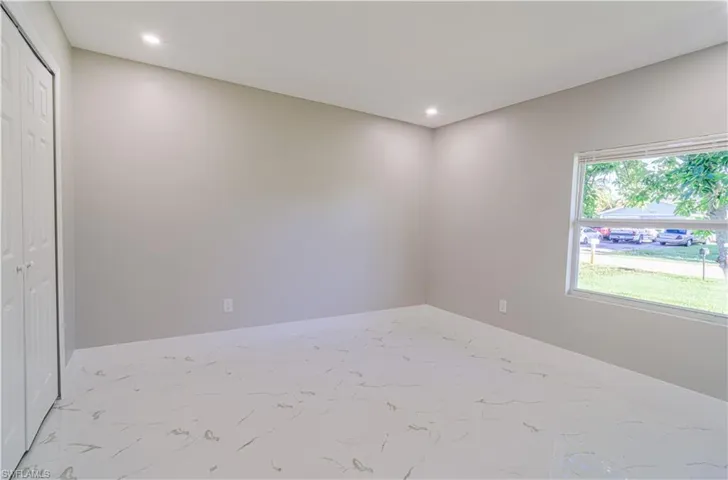 Unfurnished bedroom with recessed lighting, a closet, and marble look tile flooring