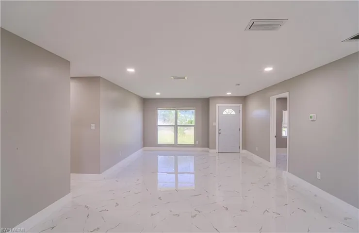 Entrance foyer with light marble finish floors and recessed lighting