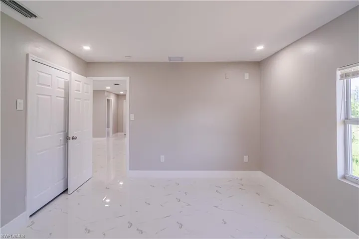 Unfurnished room featuring recessed lighting and light marble finish flooring