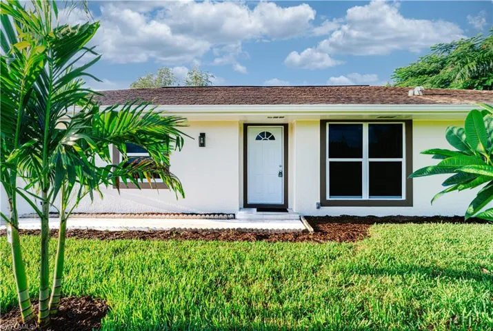 Doorway to property with stucco siding and a yard