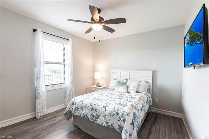 Bedroom featuring wood finished floors, baseboards, and ceiling fan