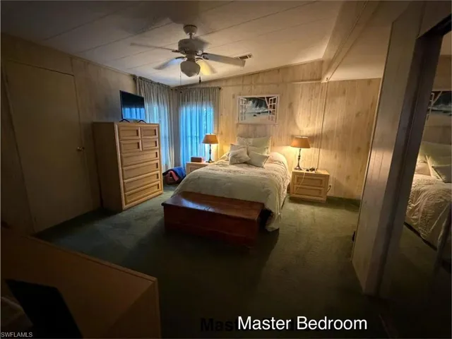 Bedroom with carpet floors, ceiling fan, and vaulted ceiling