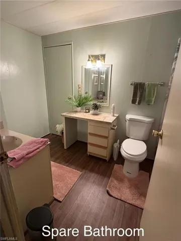 Full bath with vanity and dark wood finished floors