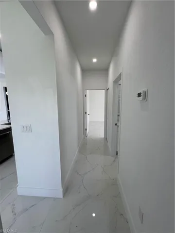 Hall featuring recessed lighting and light marble finish floors