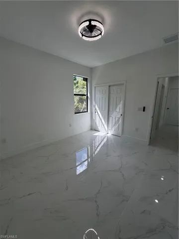 Unfurnished bedroom featuring a closet and light marble finish floors