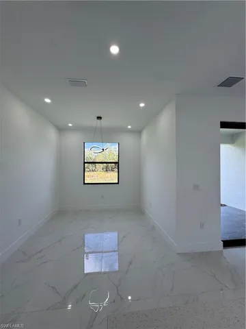 Spare room featuring recessed lighting and light marble finish flooring
