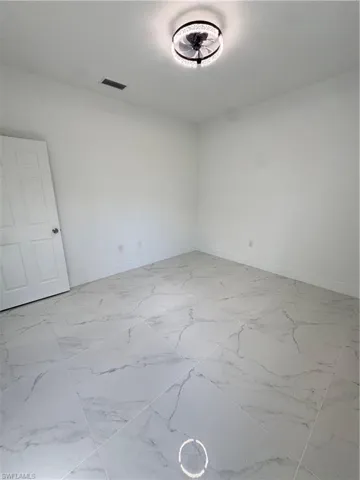 Empty room with baseboards and light marble finish floors