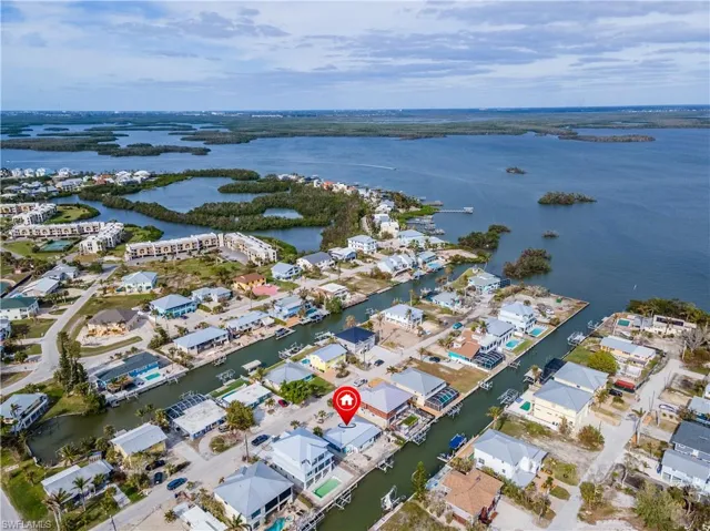 Aerial view of property and surrounding area featuring a nearby body of water and nearby suburban area