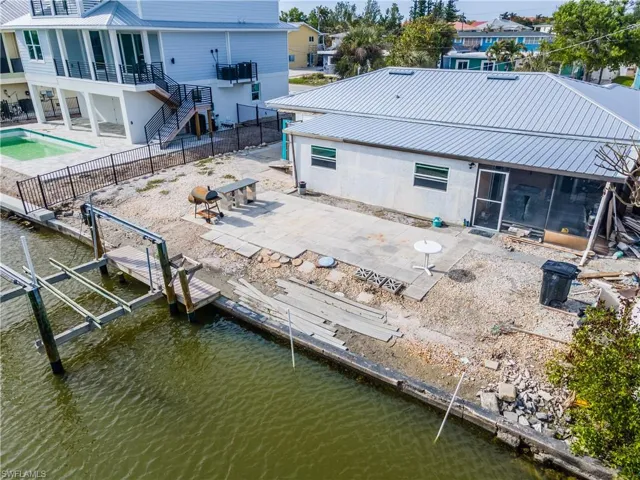 Back of house with a sunroom, stairs, a patio area, a fenced backyard, and a metal roof