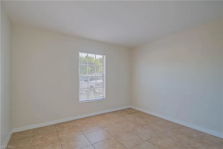 Spare room featuring baseboards and light tile patterned floors