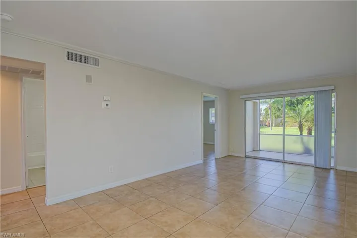 Empty room featuring crown molding and light tile patterned floors