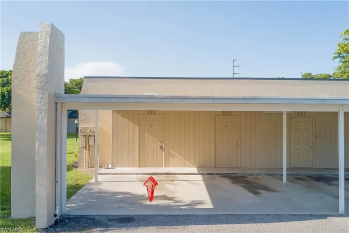 Doorway to property featuring covered parking