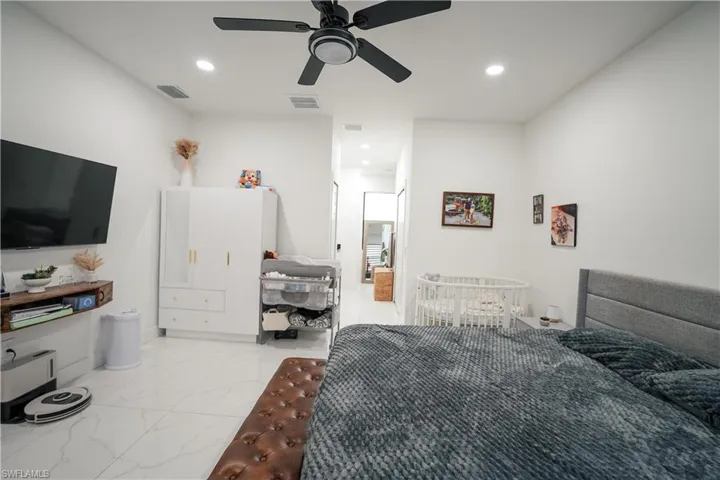 Bedroom featuring recessed lighting, light marble finish flooring, and ceiling fan