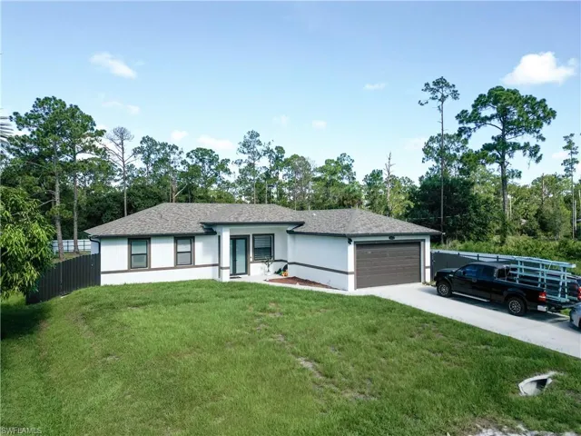 Ranch-style home featuring an attached garage, stucco siding, driveway, and a shingled roof