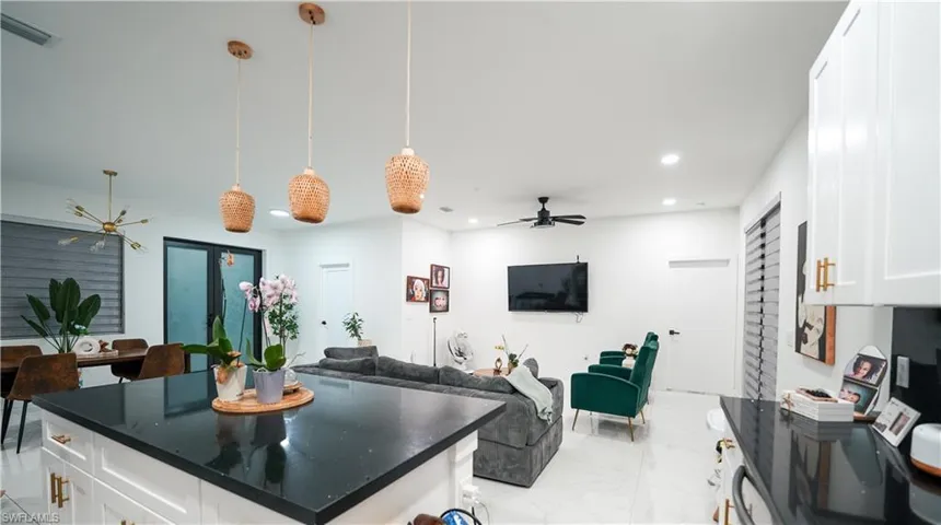 Kitchen featuring open floor plan, white cabinetry, light marble finish floors, recessed lighting, and a ceiling fan
