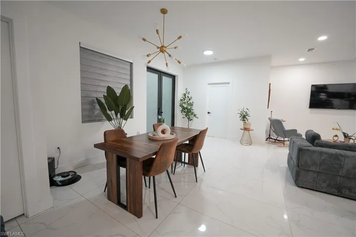 Dining space with light marble finish flooring, recessed lighting, and a chandelier