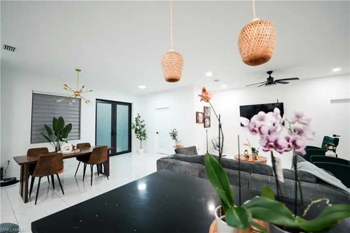 Living room featuring a chandelier, recessed lighting, french doors, and ceiling fan
