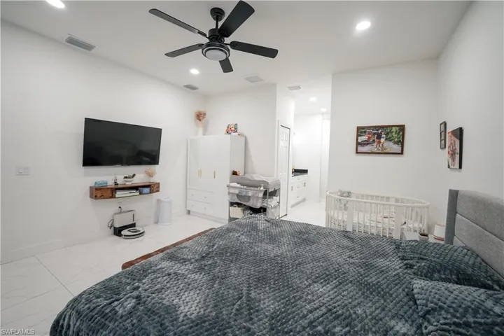 Bedroom featuring marble look tiles, recessed lighting, and a ceiling fan