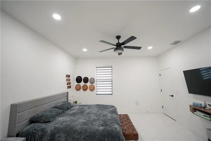 Bedroom featuring light marble finish flooring, recessed lighting, and ceiling fan