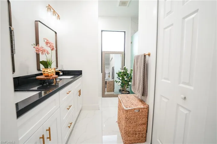 Bathroom featuring marble look tile flooring and double vanity