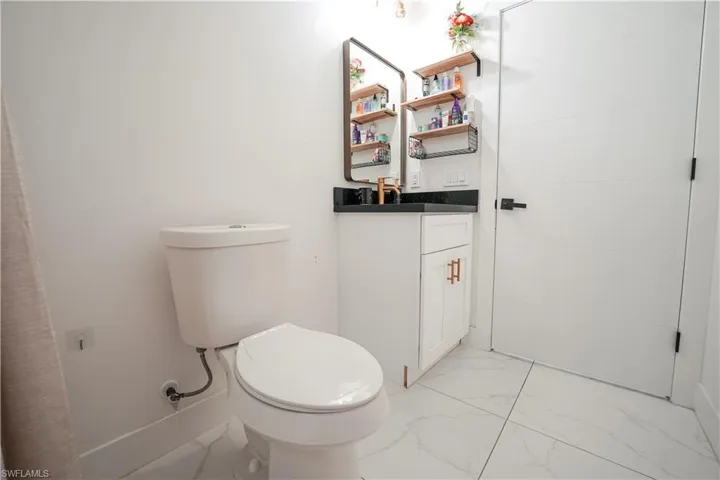 Bathroom featuring marble finish flooring and vanity