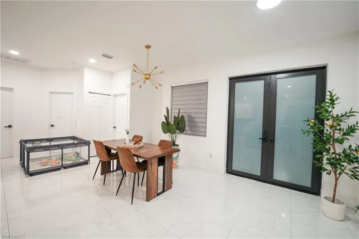 Dining area with recessed lighting, light marble finish flooring, and a chandelier