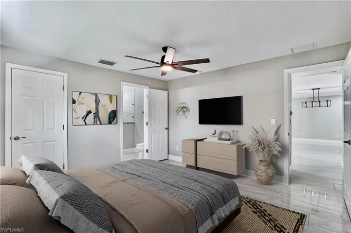 Bedroom featuring ceiling fan and ensuite bath and walk in closet