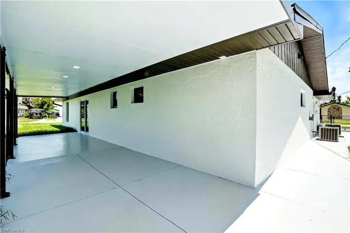 View of side of property with stucco siding, a patio, and an attached patio