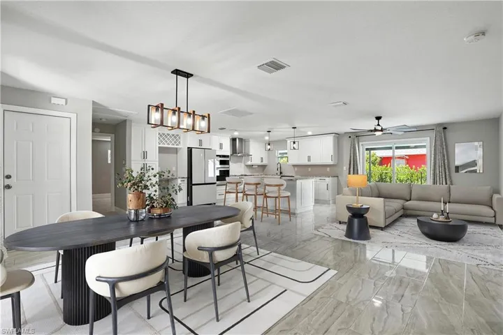 Dining space featuring light marble finish flooring and chandelier