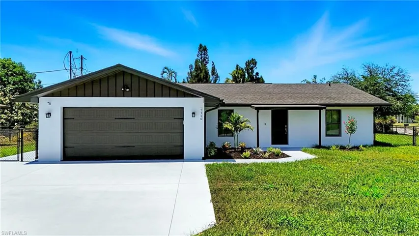 Ranch-style house featuring an attached garage, driveway, board and batten siding, and stucco siding