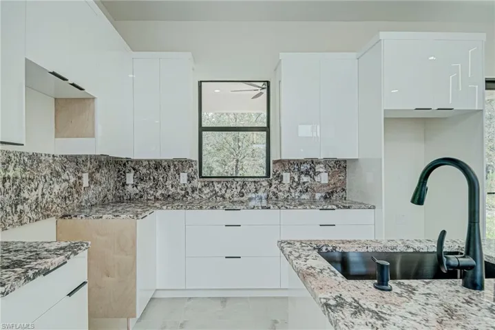 Kitchen featuring modern cabinets and white cabinets