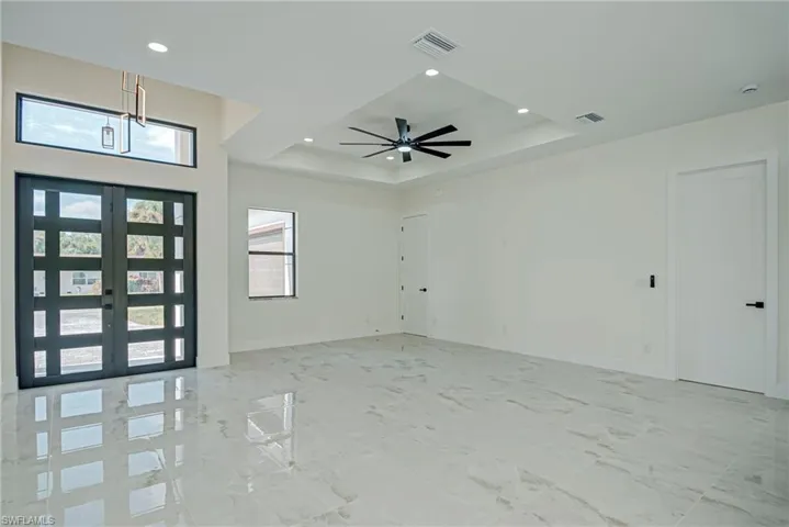 Entryway with french doors, a tray ceiling, and recessed lighting