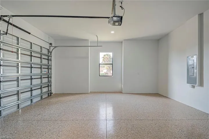 Garage featuring a garage door opener and recessed lighting