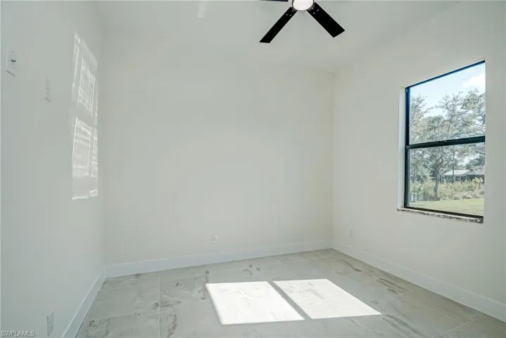 Spare room with baseboards and ceiling fan