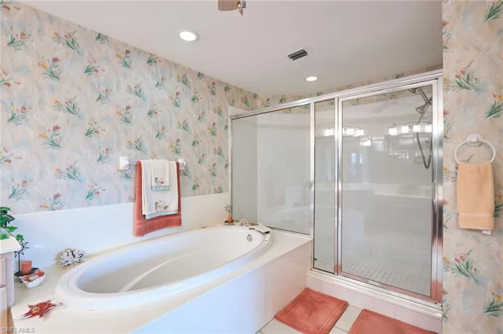 Full bathroom featuring wallpapered walls, a garden tub, a stall shower, and recessed lighting