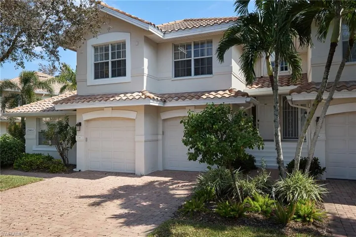 Mediterranean / spanish-style house with a garage, a tiled roof, stucco siding, and decorative driveway