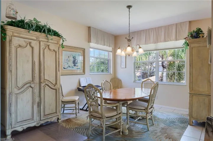 Dining area featuring a chandelier, light tile patterned floors, and healthy amount of natural light