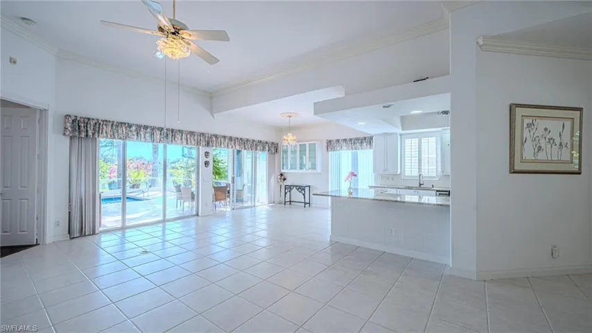 Kitchen featuring white cabinetry, light stone countertops, a ceiling fan, crown molding, and appliances with stainless steel finishes
