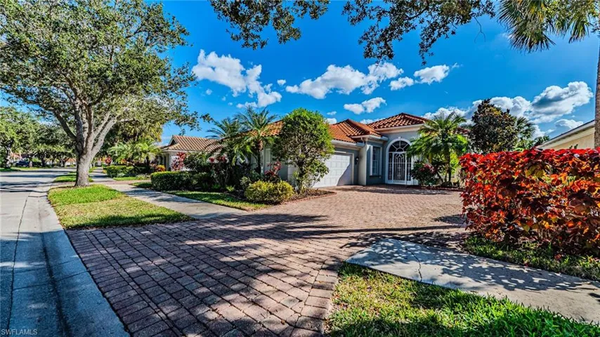 Mediterranean / spanish house with a tile roof, an attached garage, driveway, and stucco siding