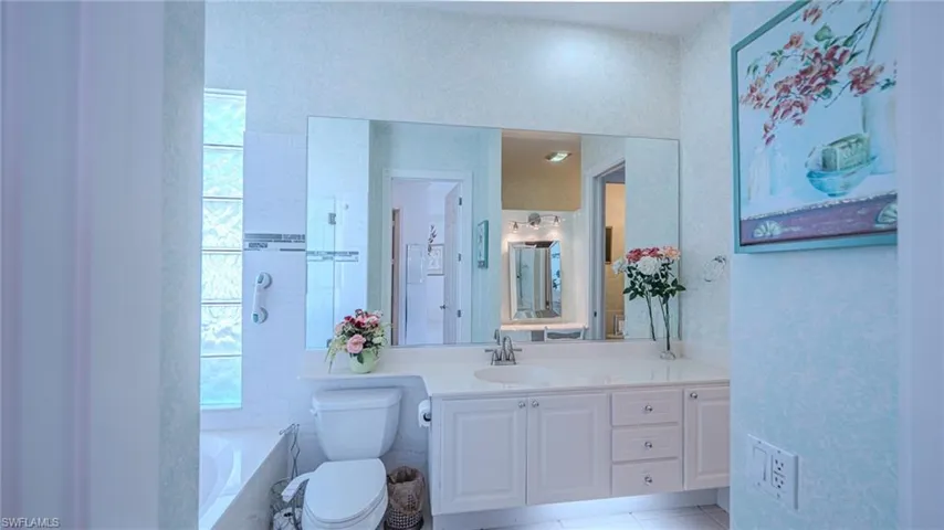 Full bath with a garden tub, vanity, and light tile patterned floors