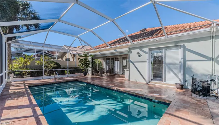 Swimming pool with a sunroom, a patio area, and a lanai