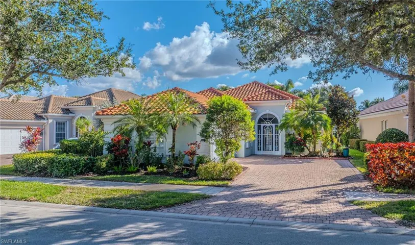 Mediterranean / spanish home with a tile roof, stucco siding, a garage, and decorative driveway