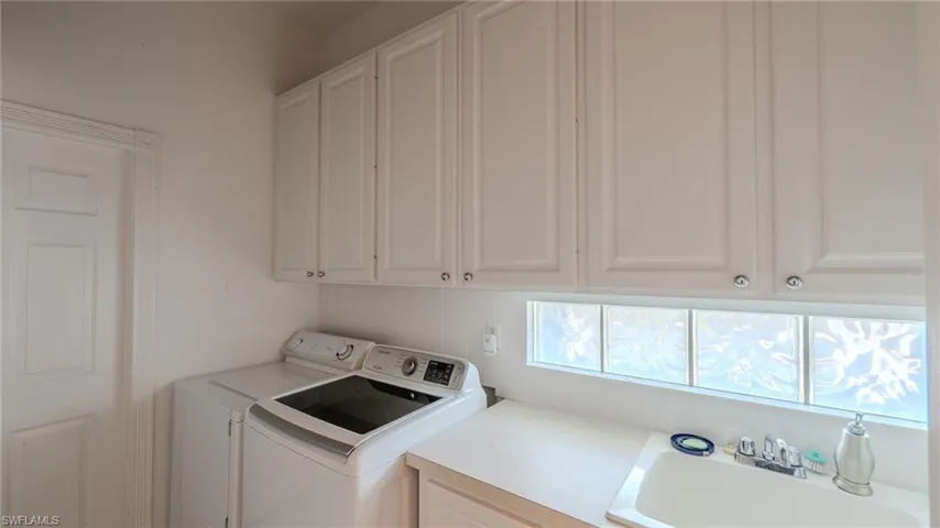 Laundry area featuring washing machine and dryer and cabinet space